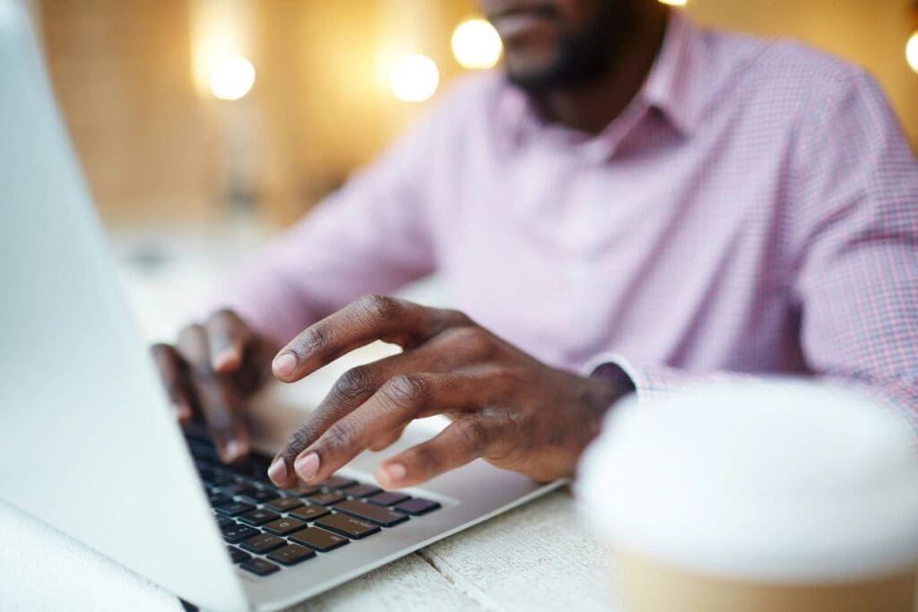 A man is typing on his laptop