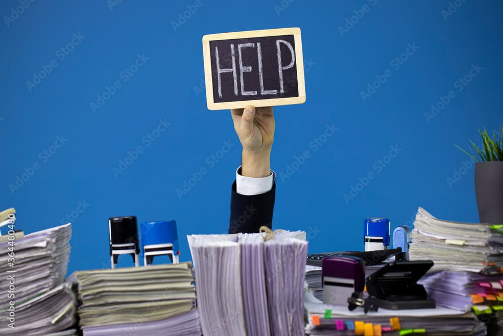 A person holding up a sign that says help.